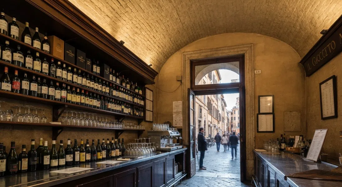 El interior abovedado de Il Goccetto en Via dei Banchi Vecchi, filas de botellas y algunos vasos en la barra con luz vespertina en la puerta